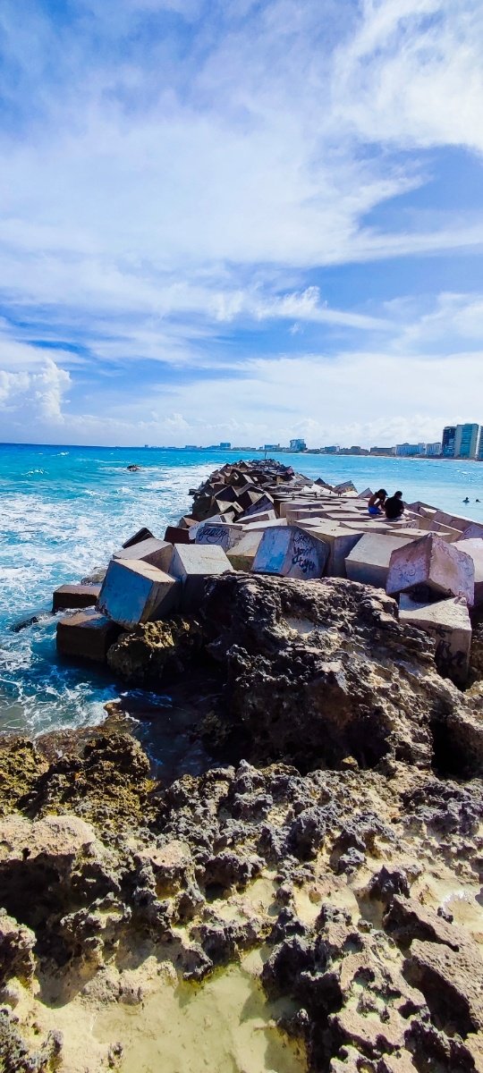 Vista del rompeolas en Playa Gaviota azul, Cancún, con grandes bloques de concreto y el mar azul. © 2024 Castor Daniel Oregel Maldonado